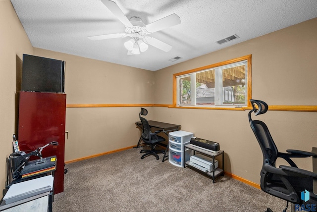 carpeted office with a ceiling fan, baseboards, and a textured ceiling