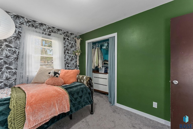 carpeted bedroom featuring baseboards and a closet