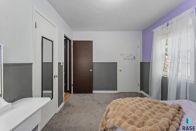 carpeted bedroom featuring wainscoting