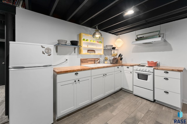 kitchen featuring white appliances, butcher block countertops, a sink, open shelves, and light wood-style flooring