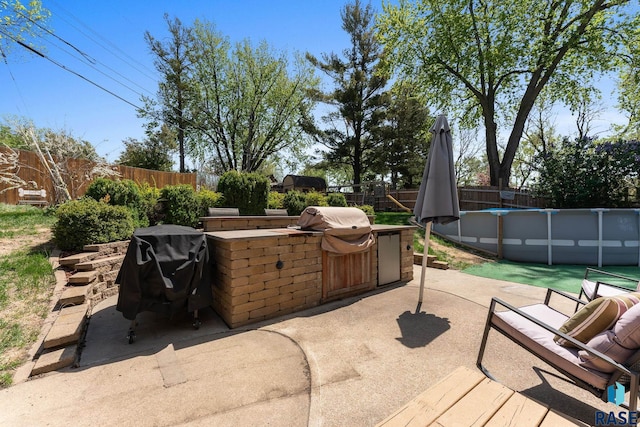 view of patio featuring an outdoor kitchen, a fenced backyard, and area for grilling