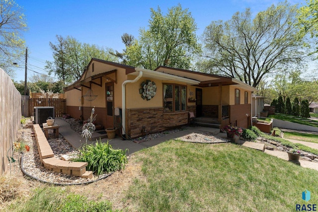 back of property with cooling unit, stone siding, and stucco siding