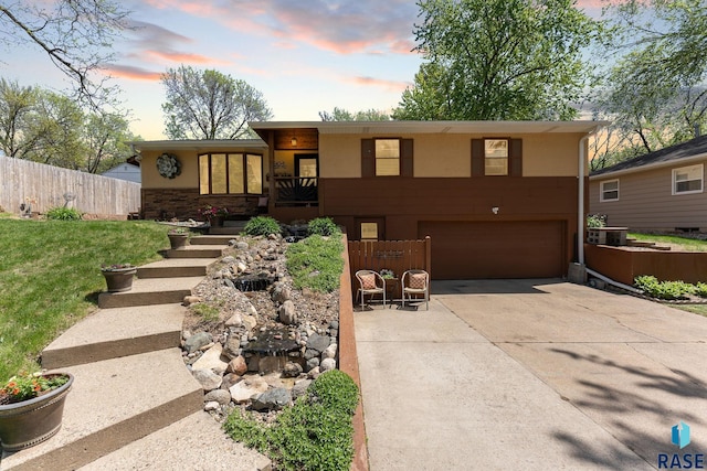 view of front facade featuring an attached garage, concrete driveway, and stucco siding