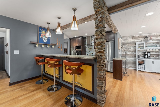 kitchen with stainless steel appliances, a kitchen breakfast bar, light wood-style floors, a peninsula, and recessed lighting