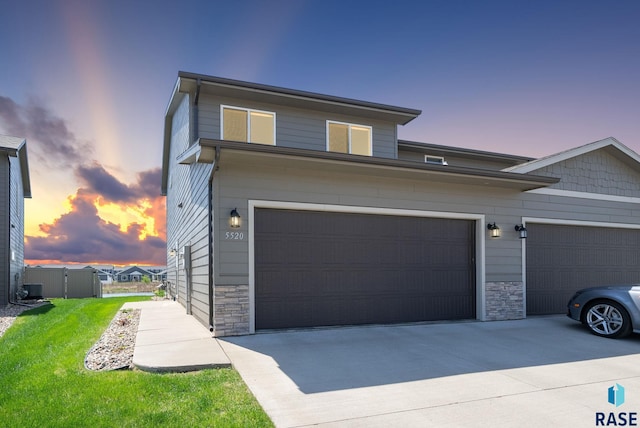 5520 S Seville Pl, Sioux Falls, SD 57108 - view of front of house featuring stone siding, driveway, and a lawn