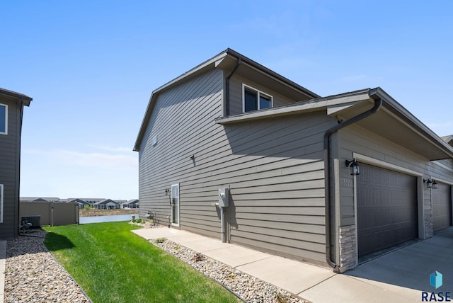 5520 S Seville Pl, Sioux Falls, SD 57108 - view of side of property featuring an attached garage, stone siding, and driveway