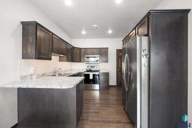 5520 S Seville Pl, Sioux Falls, SD 57108 - kitchen featuring appliances with stainless steel finishes, a sink, dark brown cabinetry, dark wood-style floors, and a peninsula