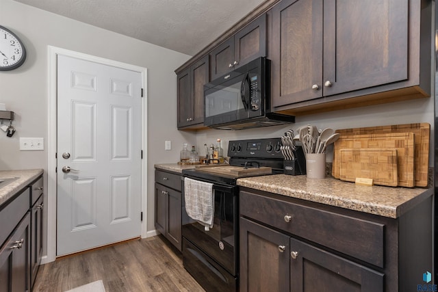 kitchen featuring black appliances, dark brown cabinets, dark wood-style flooring, and light countertops