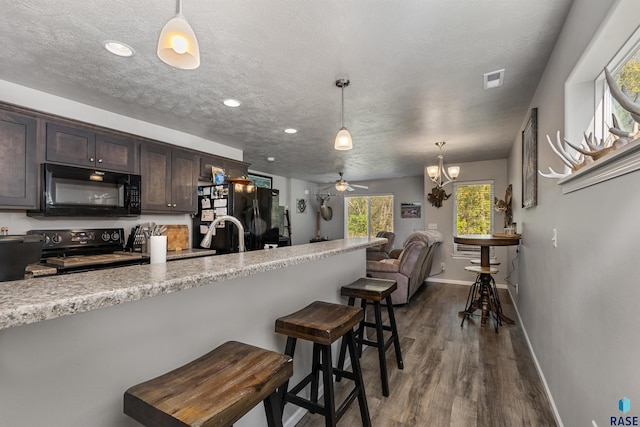 kitchen with black appliances, baseboards, dark brown cabinetry, dark wood-style flooring, and decorative light fixtures