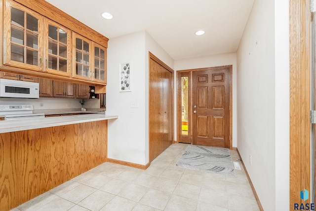 110 W Apple St, Tea, SD 57064 - kitchen with white appliances, glass insert cabinets, light countertops, baseboards, and recessed lighting