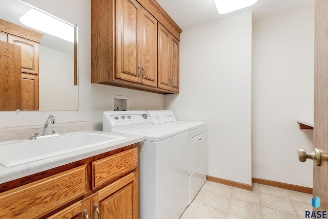 110 W Apple St, Tea, SD 57064 - laundry room featuring washer and dryer, cabinet space, light tile patterned flooring, and baseboards