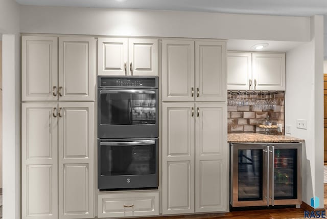 904 W Chicory Ln, Sioux Falls, SD 57108 - kitchen with double oven, beverage cooler, white cabinetry, and decorative backsplash