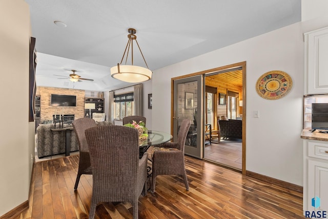 904 W Chicory Ln, Sioux Falls, SD 57108 - dining space featuring ceiling fan, dark wood-style floors, a fireplace, and baseboards