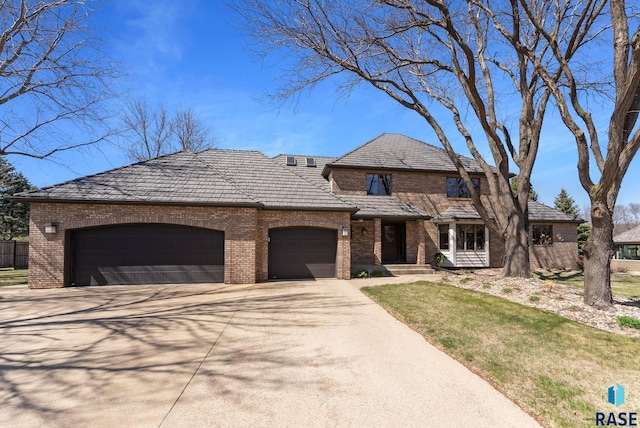 904 W Chicory Ln, Sioux Falls, SD 57108 - view of front facade with brick siding, a garage, driveway, and fence