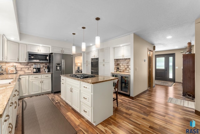 904 W Chicory Ln, Sioux Falls, SD 57108 - kitchen with appliances with stainless steel finishes, tasteful backsplash, a kitchen island, white cabinetry, and beverage cooler