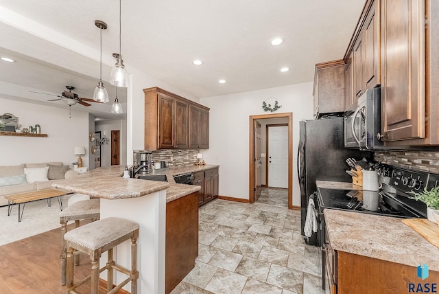 615 Marsha Cir, Tea, SD 57064 - kitchen featuring black appliances, open floor plan, decorative backsplash, a breakfast bar area, and a ceiling fan