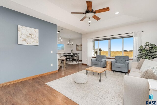 615 Marsha Cir, Tea, SD 57064 - living area with a ceiling fan, wood finished floors, a tray ceiling, baseboards, and a chandelier