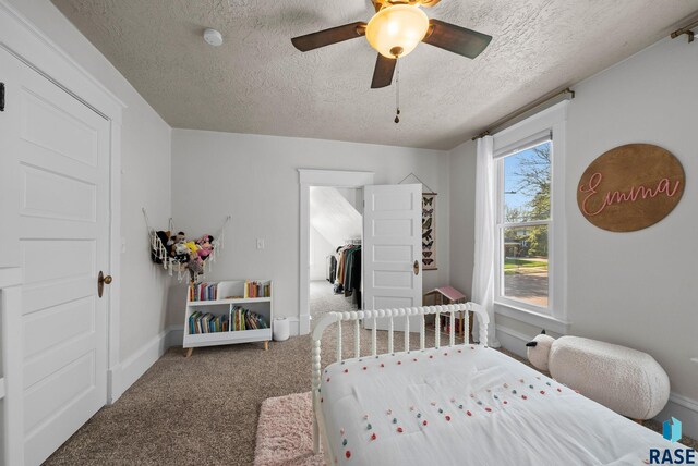 bedroom with carpet floors, a textured ceiling, ceiling fan, and baseboards