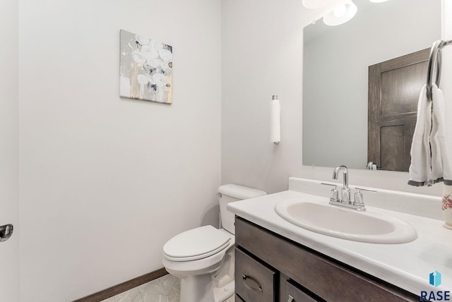 half bath with vanity, toilet, and baseboards