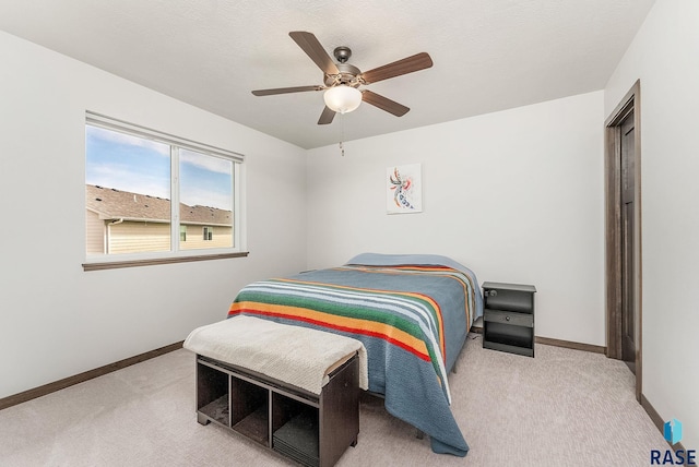 carpeted bedroom with baseboards and a ceiling fan