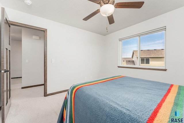 bedroom featuring light carpet, baseboards, and a ceiling fan