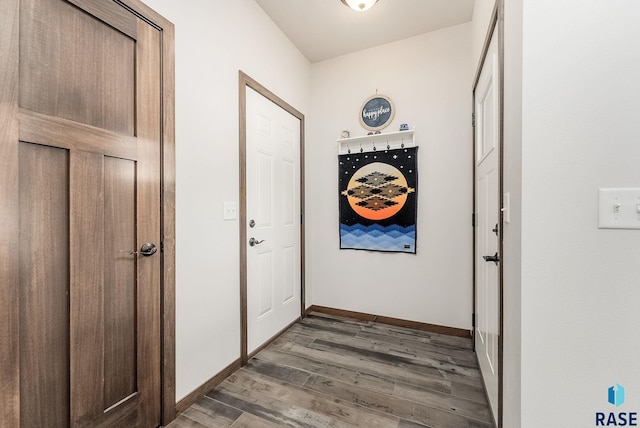 hallway featuring wood finished floors and baseboards