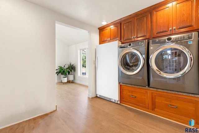 28262 472nd Ave, Worthing, SD 57077 - clothes washing area with washer and clothes dryer, light wood-style flooring, cabinet space, and baseboards