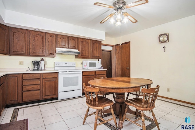 kitchen featuring white appliances, under cabinet range hood, light tile patterned floors, a ceiling fan, and light countertops