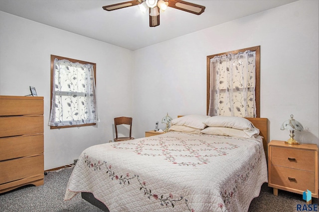 bedroom with dark colored carpet, ceiling fan, and baseboards