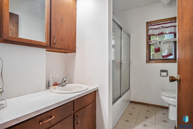 full bathroom with toilet, vanity, baseboards, and shower / bath combination with glass door