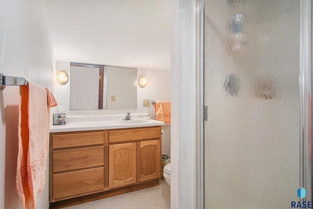 full bathroom with a stall shower, vanity, and toilet