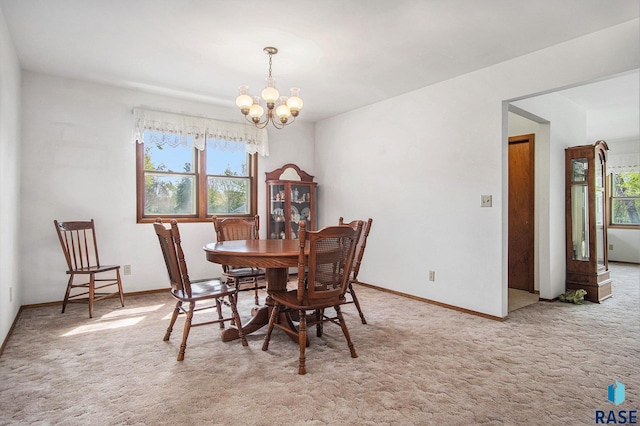 dining area featuring a chandelier, carpet floors, and healthy amount of natural light