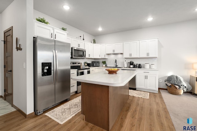 8162 E Tencate Pl, Sioux Falls, SD 57110 - kitchen with appliances with stainless steel finishes, a sink, white cabinets, light wood-type flooring, and recessed lighting