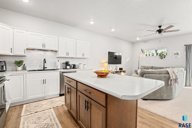 8162 E Tencate Pl, Sioux Falls, SD 57110 - kitchen featuring a sink, stainless steel dishwasher, open floor plan, light countertops, and light wood finished floors