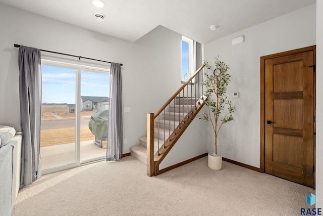 8162 E Tencate Pl, Sioux Falls, SD 57110 - foyer with light colored carpet, stairway, and baseboards