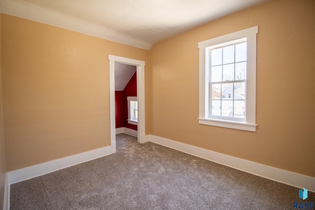 empty room featuring dark carpet and baseboards