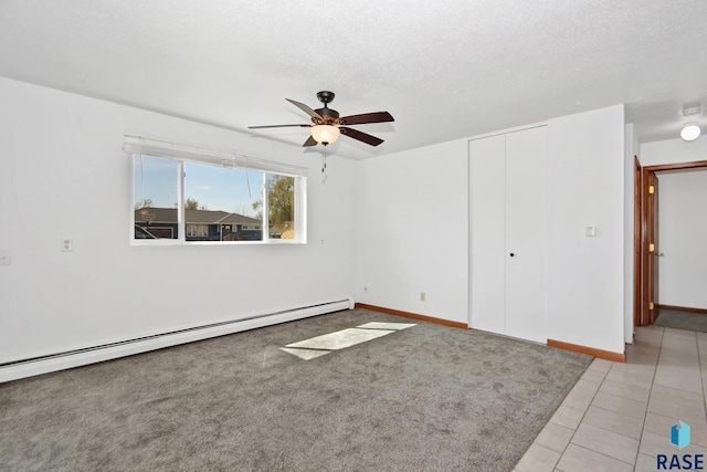 310 Jackson St, Valley Springs, SD 57068 - empty room featuring a baseboard heating unit, a ceiling fan, light tile patterned flooring, baseboards, and a textured ceiling