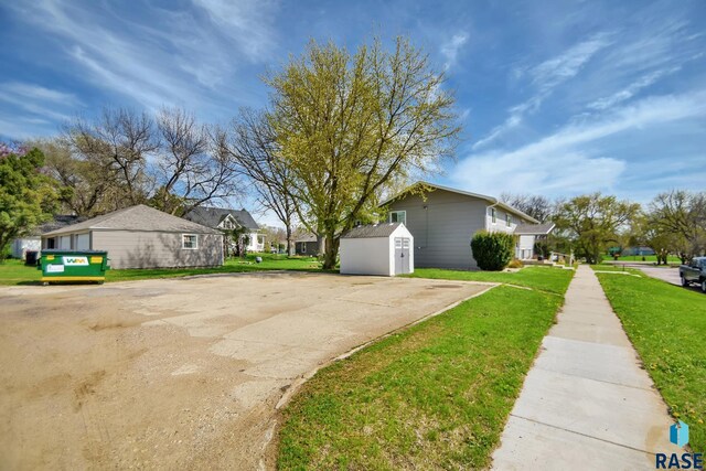 310 Jackson St, Valley Springs, SD 57068 - view of side of home with a storage shed, an outdoor structure, a lawn, and a residential view