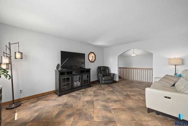 living room featuring arched walkways and baseboards