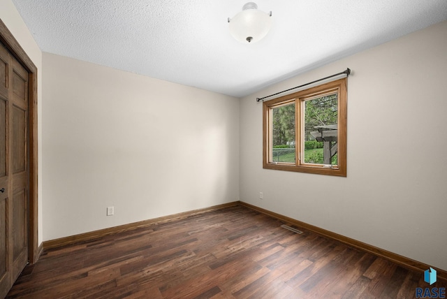 empty room featuring wood finished floors and baseboards