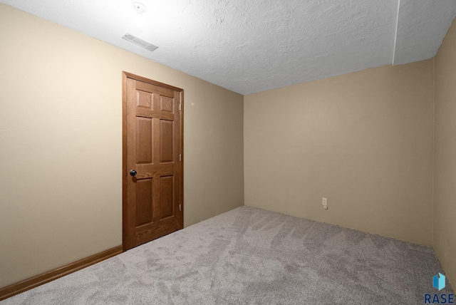carpeted spare room featuring a textured ceiling