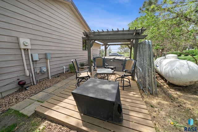 wooden deck with a hot tub, a pergola, outdoor dining space, and a patio