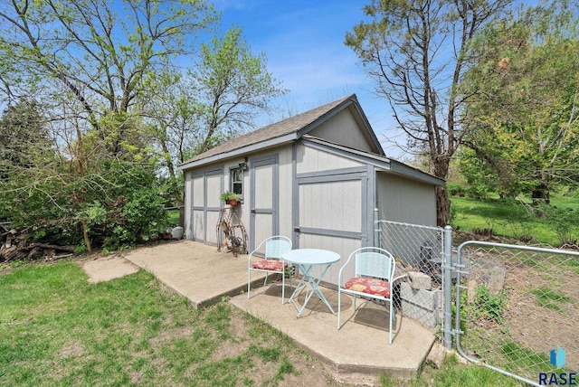 view of shed featuring fence and a gate