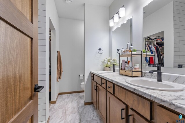 5307 S Dubuque Ave, Sioux Falls, SD 57108 - bathroom featuring toilet, double vanity, and a walk in closet