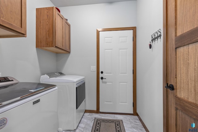 5307 S Dubuque Ave, Sioux Falls, SD 57108 - laundry room featuring cabinet space, separate washer and dryer, light marble finish flooring, and baseboards