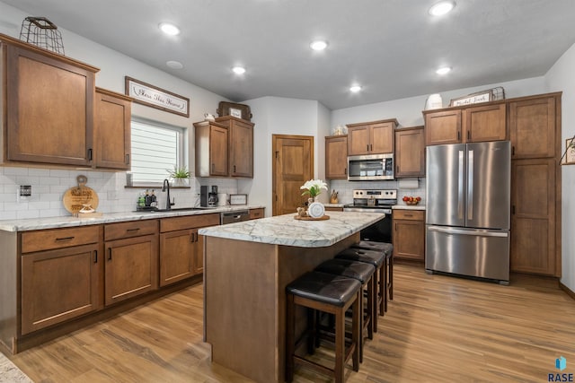 5307 S Dubuque Ave, Sioux Falls, SD 57108 - kitchen featuring appliances with stainless steel finishes, a sink, wood finished floors, a center island, and light countertops