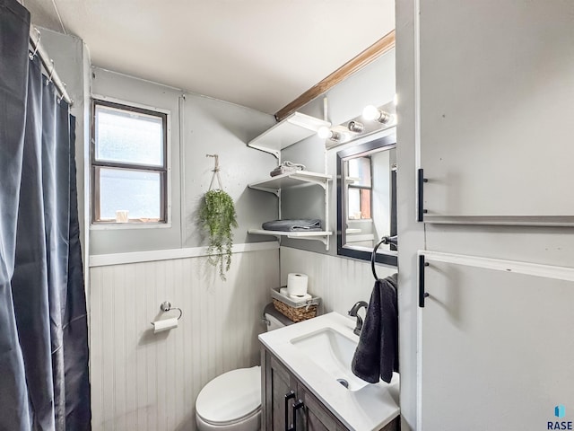 bathroom featuring wainscoting, vanity, toilet, and a shower with curtain
