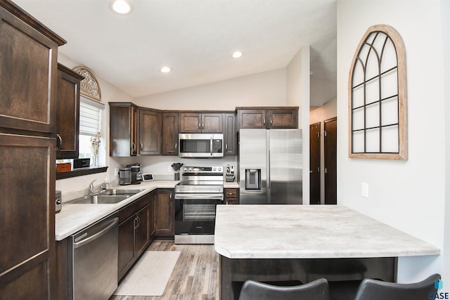 9425 W Liam St, Sioux Falls, SD 57106 - kitchen with stainless steel appliances, a sink, lofted ceiling, dark brown cabinets, and light countertops