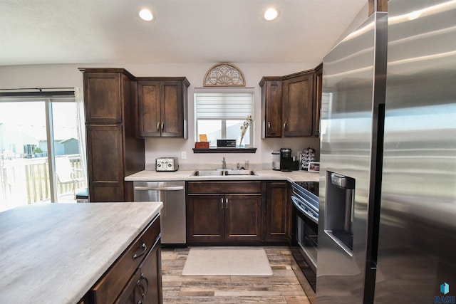 9425 W Liam St, Sioux Falls, SD 57106 - kitchen with stainless steel appliances, a sink, dark brown cabinets, light wood finished floors, and light countertops