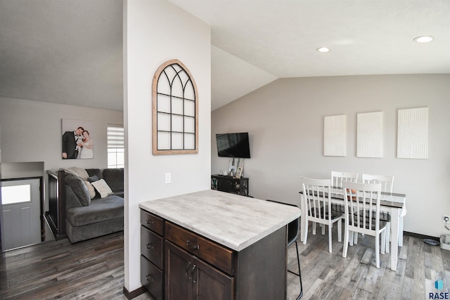 9425 W Liam St, Sioux Falls, SD 57106 - kitchen featuring a breakfast bar, dark brown cabinets, wood finished floors, lofted ceiling, and light countertops